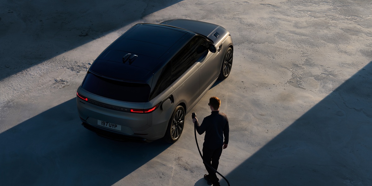 Nieuwe Range Rover Sport Electric combineert 609 km actieradius met supersnel laden Range Rover Sport Electric van bovenaf gefotografeerd terwijl een bestuurder de elektrische SUV gaat opladen.